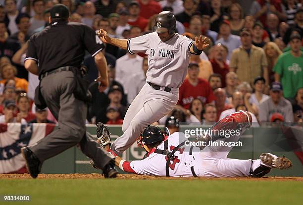 Jorge Posada of the New York Yankees scores as Victor Martinez of the Boston Red Sox fails to handle the throw at Fenway Park on April 7, 2010 in...
