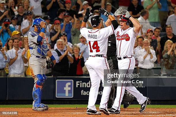Catcher Geovany Soto of the Chicago Cubs watches as Martin Prado congratulates Chipper Jones of the Atlanta Braves after Jones' two-run homer in the...