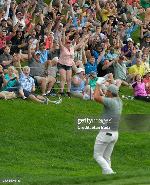 Fans celebrate with Jason Day of Australia after his chip in for birdie on the 18th hole during the final round of the Travelers Championship at TPC...