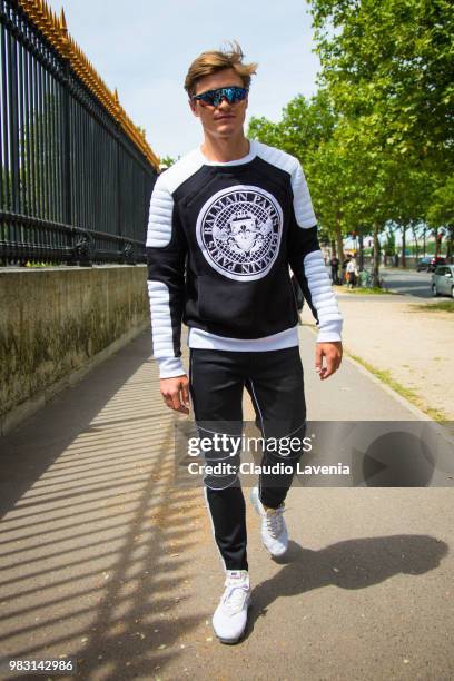 Oliver Cheshire, wearing Balmain sweater, Balmain pants and Nike sneakers, is seen in the streets of Paris before the Balmain show, during Paris...