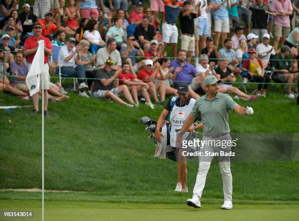 Fans celebrate with Jason Day of Australia after his chip in for birdie on the 18th hole during the final round of the Travelers Championship at TPC...