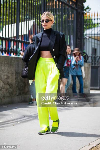 Caro Daur, wearing black top, Balmin black jacket and fluo pants, is seen in the streets of Paris before the Balmain show, during Paris Men's Fashion...