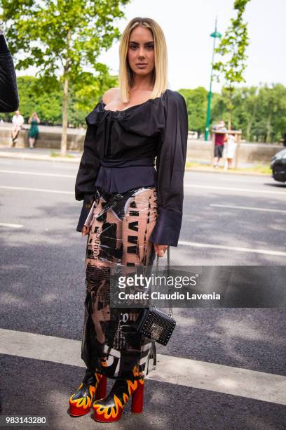 Guest, wearing black shirt, latex skirt and Balmain bag, is seen in the streets of Paris before the Balmain show, during Paris Men's Fashion Week...