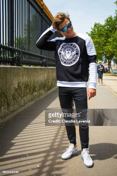 Oliver Cheshire, wearing Balmain sweater, Balmain pants and Nike sneakers, is seen in the streets of Paris before the Balmain show, during Paris...