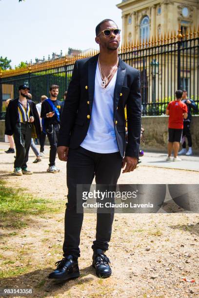 Victor Cruz, wearing white t shirt, Balmain black jacket and black pants, is seen in the streets of Paris after the Balmain show, during Paris Men's...