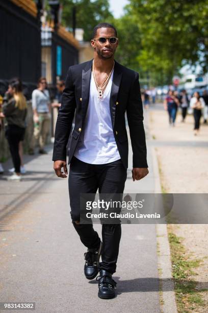Victor Cruz, wearing white t shirt, Balmain black jacket and black pants, is seen in the streets of Paris before the Balmain show, during Paris Men's...