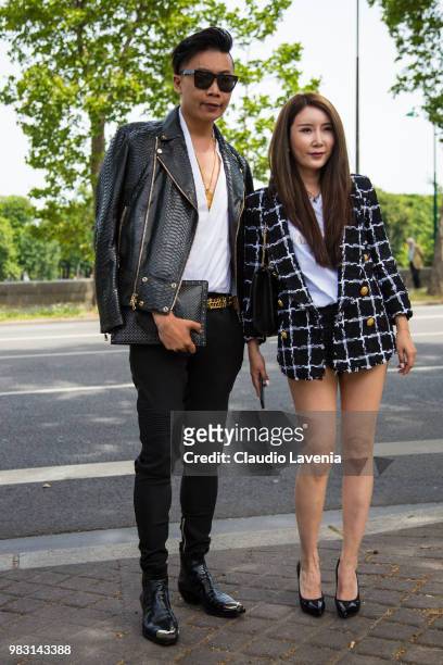 Guests, wearing white shirt, black leather jacket and Balmain hand bag, and checked jacket and white shirt, are seen in the streets of Paris before...