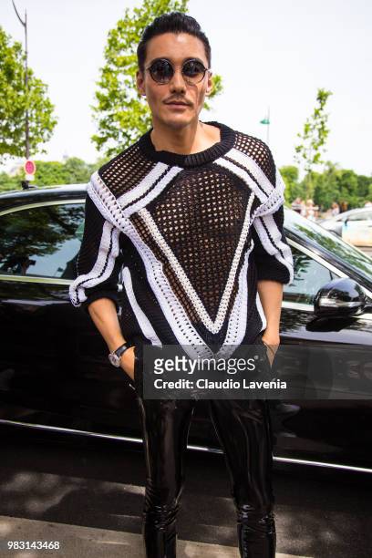 Hu Bing, wearing black and white sweater and black pants, is seen in the streets of Paris before the Balmain show, during Paris Men's Fashion Week...