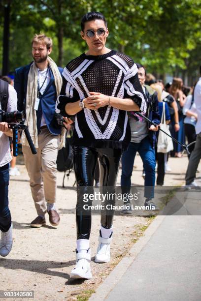Hu Bing, wearing black and white sweater and black latex pants , is seen in the streets of Paris after the Balmain show, during Paris Men's Fashion...