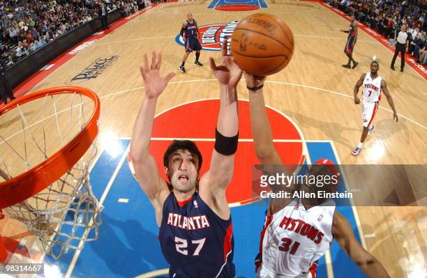 Charlie Villanueva of the Detroit Pistons goes up for a rebound against Zaza Pachulia of the Atlanta Hawks in a game at the Palace of Auburn Hills on...