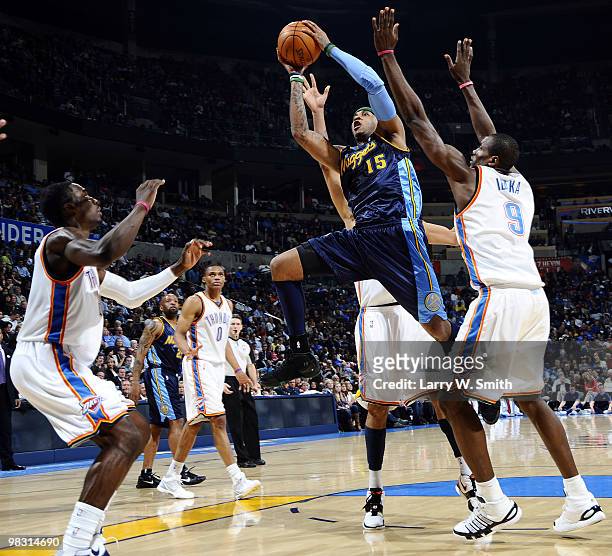 Carmelo Anthony of the Denver Nuggets goes to the basket against Jeff Green and Serge Ibaka of the Oklahoma City Thunder during the game at the Ford...