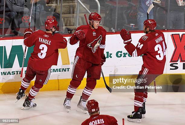 Lauri Korpikoski of the Phoenix Coyotes celebrates with teammates Keith Yandle and Daniel Winnik after scoring a first period goal against the...