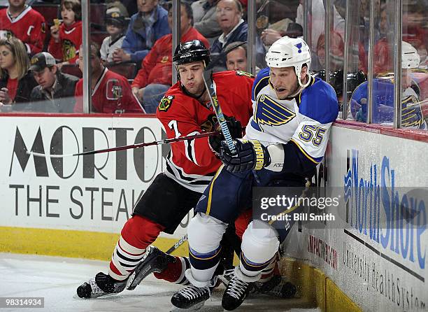 Brent Seabrook of the Chicago Blackhawks pushes Cam Janssen of the St. Louis Blues from along the boards on April 07, 2010 at the United Center in...