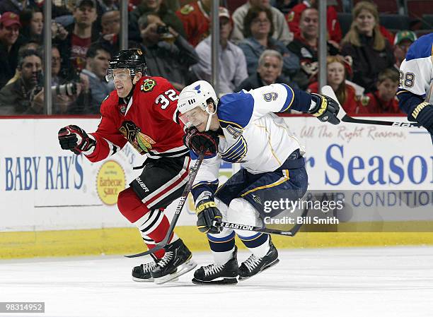 Kris Versteeg of the Chicago Blackhawks and Paul Kariya of the St. Louis Blues chase after the puck on April 07, 2010 at the United Center in...
