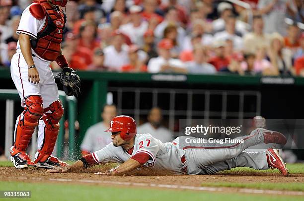 Placido Polanco of the Philadelphia Phillies slides safely into home plate in the seventh inning against the Washington Nationals at Nationals Park...