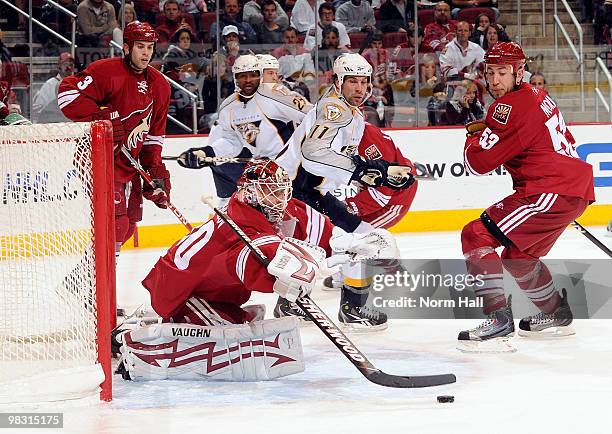 Ilya Bryzgalov of the Phoenix Coyotes brings in a rebound before teammate Derek Morris or David Legwand of the Nashville Predators can get to it on...