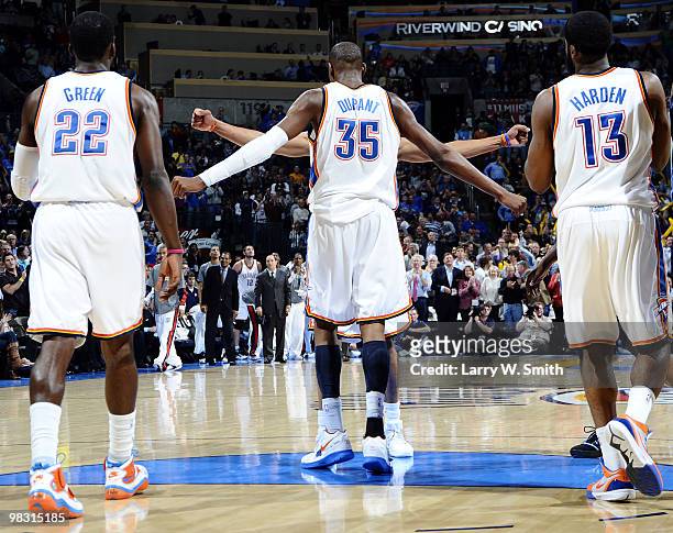 Jeff Green, Kevin Durant, chest bumping Russell Westbrook 30, and James Harden of the Oklahoma City Thunder pause during action against the Denver...