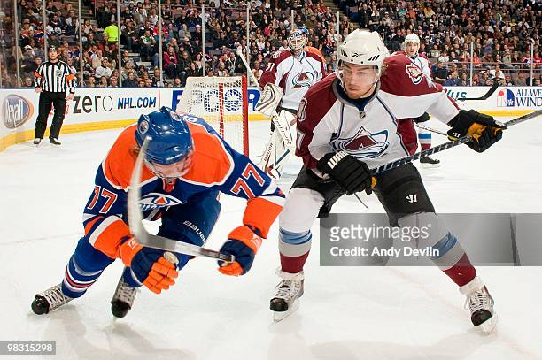 Tom Gilbert of the Edmonton Oilers tries to dodge a check from Ryan O'Reilly of the Colorado Avalanche at Rexall Place on April 7, 2010 in Edmonton,...