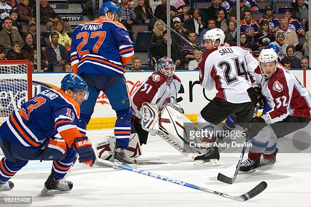 Peter Budaj of the Colorado Avalanche keeps his eye on the puck through a maze of screening players against the Edmonton Oilers at Rexall Place on...