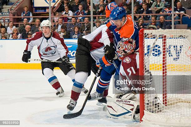 Charles Linglet of the Edmonton Oilers is forced into Peter Budaj of the Colorado Avalanche at Rexall Place on April 7, 2010 in Edmonton, Alberta,...