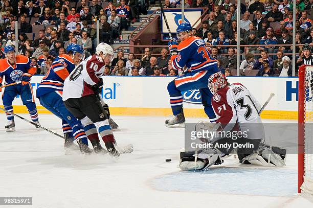 Peter Budaj of the Colorado Avalanche makes a save through a maze of players against the Edmonton Oilers at Rexall Place on April 7, 2010 in...