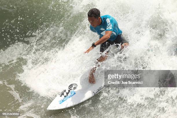 Ariihoe Tefaafana of French Polynesia races down a wave during his quarter final heat at the 2018 Shoe City Pro at the Huntington Beach Pier on June...