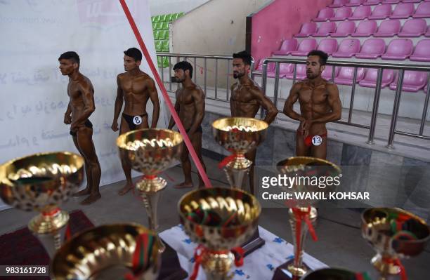 This photo taken on April 18, 2018 shows Afghan bodybuilders waiting to compete in a bodybuilding and fitness contest in Kabul. - Hindi music pumps...