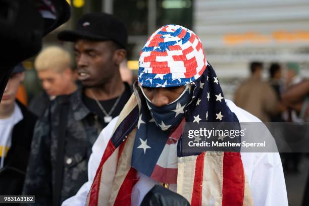 Bari is seen on the street during Paris Men's Fashion Week S/S 2019 wearing an American flag design head scarf with white outfit on June 24, 2018 in...