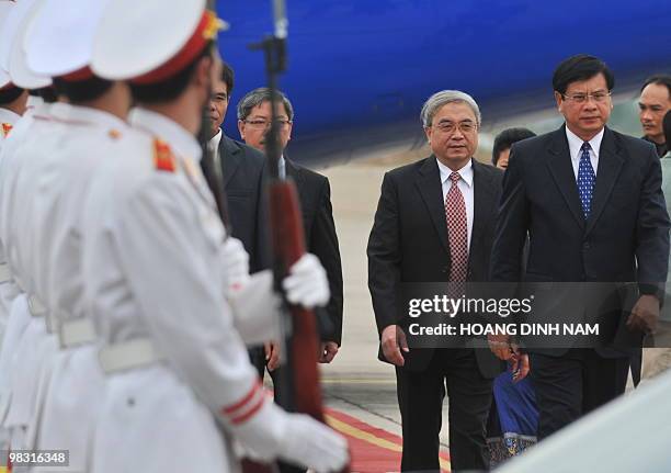 Laos Prime Minister Bouasone Bouphavanh walks past an honour guard as he arrives at Hanoi's Noi Bai international airport to attend the 16th summit...