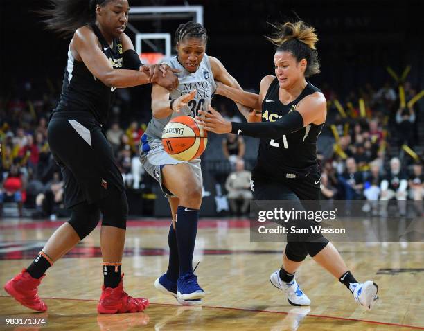 Kelsey Bone and Kayla McBride of the Las Vegas Aces battle Tanisha Wright of the Minnesota Lynx for a loose ball during their game at the Mandalay...