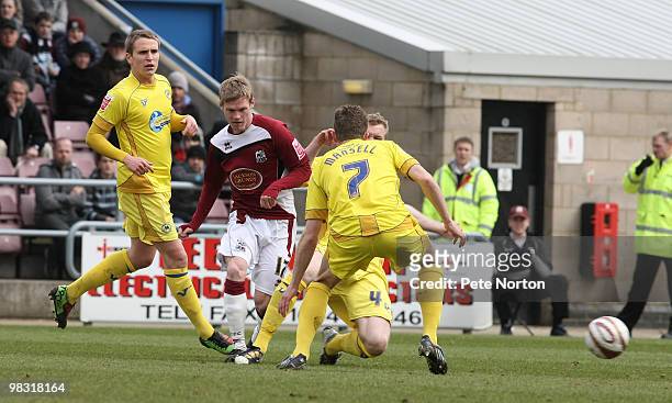 Billy McKay of Northampton Town plays the ball under pressure from Lee Mansell, Nicky Wroe and Mark Ellis of Torquay United during the Coca Cola...
