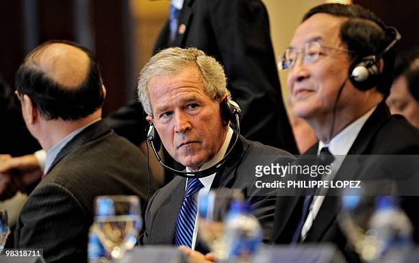 Former US president George W. Bush looks on as he sits by Secretary of the Political Bureau of the Central Committee of the CPC and Party chief of...