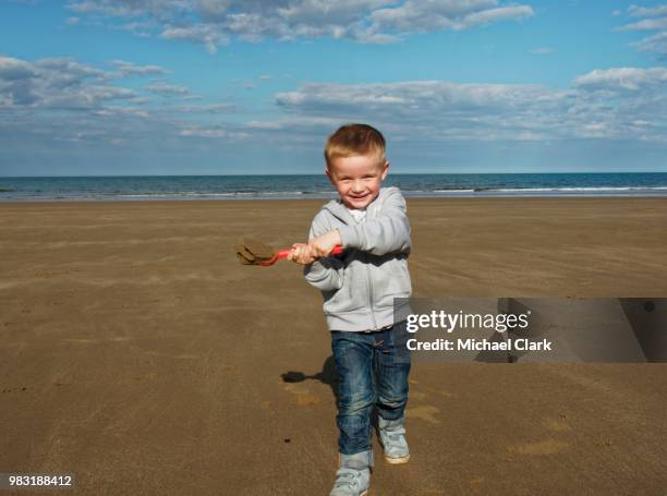 happy toddler playing on beach - michael virtue stock pictures, royalty-free photos & images