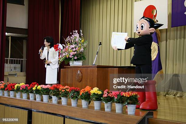 In this handout image provided by the Board of Education, Shinjuku City, Japanese famous cartoon character Tetsuwan Atom or Astro Boy recieves the...