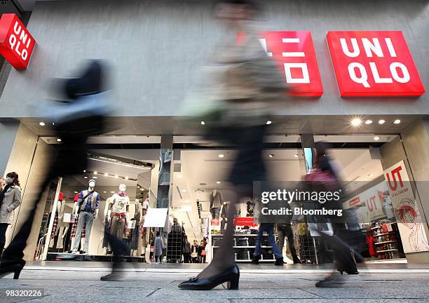 Pedestrians walk past Fast Retailing Co.'s Uniqlo store in the Ginza district of Tokyo, Japan, on Thursday, April 8, 2010. Fast Retailing Co.,...