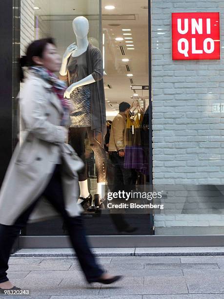 Pedestrian walks past Fast Retailing Co.'s Uniqlo store in the Ginza district of Tokyo, Japan, on Thursday, April 8, 2010. Fast Retailing Co.,...