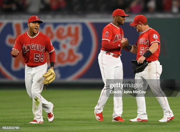 Michael Hermosillo, Justin Upton and Kole Calhoun of the Los Angeles Angels of Anaheim celebrate a 2-1 win over the Toronto Blue Jays at Angel...