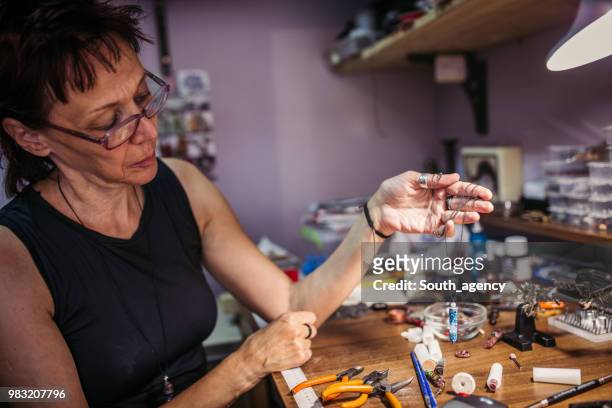 woman making jewelry in a store - jasper mineral stock pictures, royalty-free photos & images