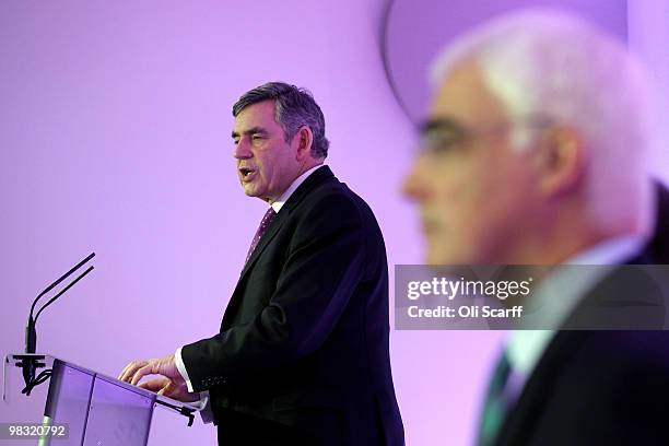 British Prime Minister Gordon Brown is watched by Alistair Darling as he speaks during the Labour party's first press conference of the election...