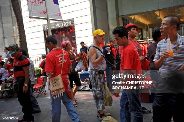 Foreign tourist walks past anti-government protesters at the site of a continued rally in central Bangkok on April 8, 2010. Thailand's economy is...