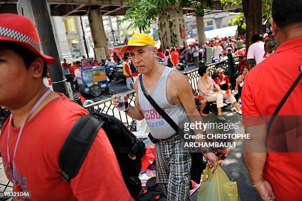 Foreign tourist walks past anti-government protesters at the site of a continued rally in central Bangkok on April 8, 2010. Thailand's economy is...