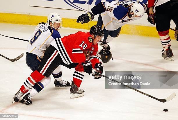 Jonathan Toews of the Chicago Blackhawks moves to the puck under pressure from Paul Kariya of the St. Louis Blues at the United Center on April 7,...