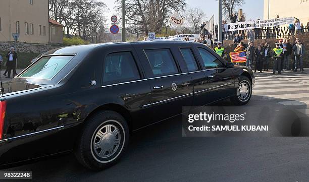 President Barack Obama in his limousine is escorted by police across Prague streets as he passes in front of demonstrators protesting against the...