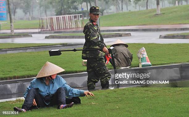 Soldier uses a metal detector to secure the surrounding areas of the My Dinh National Convention Center, the main venue for the up-comming 16th...