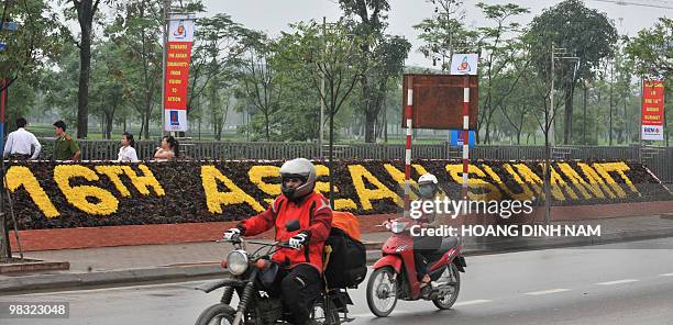 Motorcyclists ride past the My Dinh National Convention Center, the main venue for the up-comming 16th summit of the Southeast Asian Nations in Hanoi...