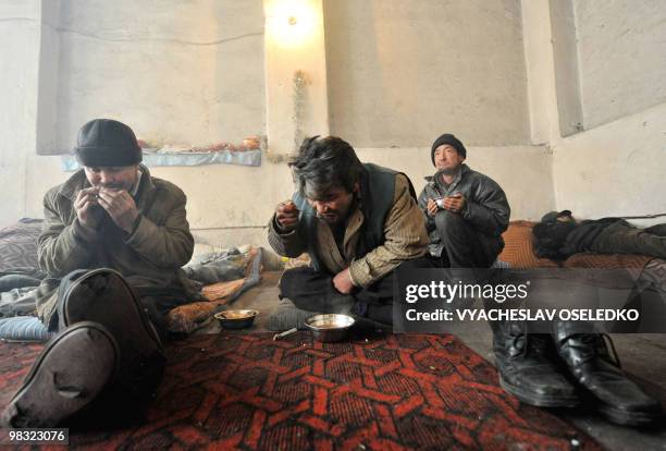 Homeless men eat food at a shelter in the Kyrgyz capital of Bishkek on February 15, 2010. The city authorities allow homeless people to occupy a...