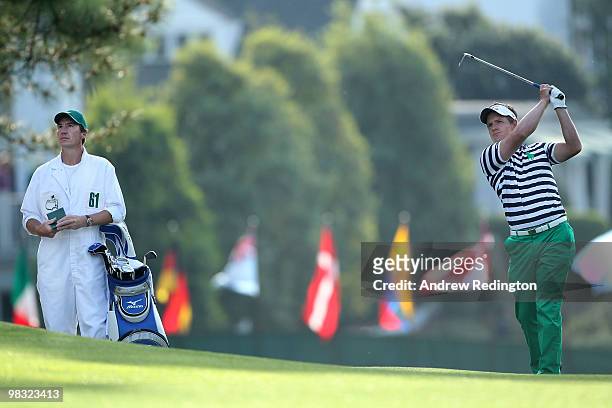 Luke Donald of England watches a shot as his caddie John McLaren waits on the second hole during the first round of the 2010 Masters Tournament at...