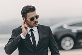 handsome bodyguard listening message with security earpiece