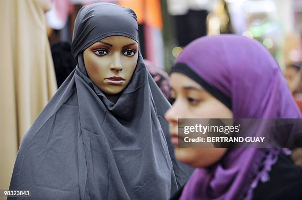 Woman walks past a dummy covered with a veil at a stand during the annual meeting of French Muslims organized by the Union of Islamic Organisations...