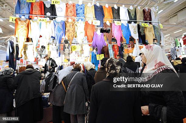Women stand by a fashion stall during the annual meeting of French Muslims organized by the Union of Islamic Organisations of France in Le Bourget,...